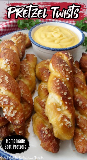 Soft pretzels on a white plate with a small bowl of queso.