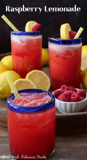 Three glasses with blue trim filled with raspberry lemonade.