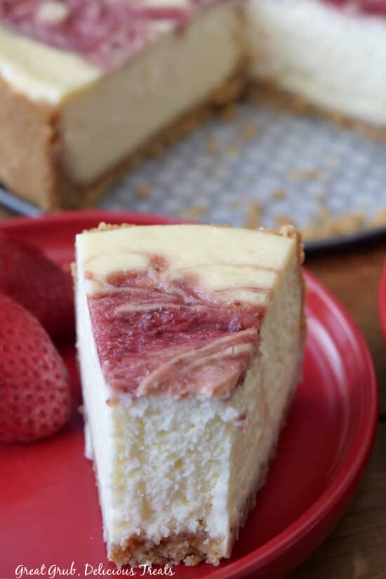 A close up of a slice of cheesecake on a red place.