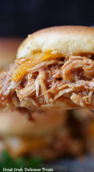 A close up of a BBQ chicken slider held close to the camera lens.