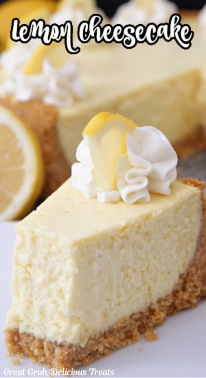 A slice of lemon cheesecake on a white plate with a bite taken out of it.