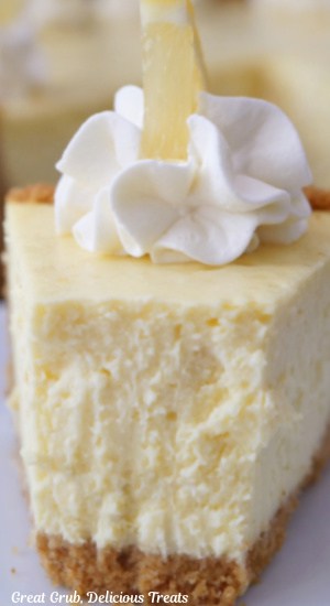 A close up photo of a piece of lemon cheesecake with a bite taken out of it.