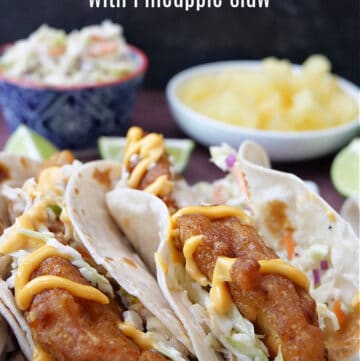 Two fish tacos in flour tortillas with pineapple slaw.