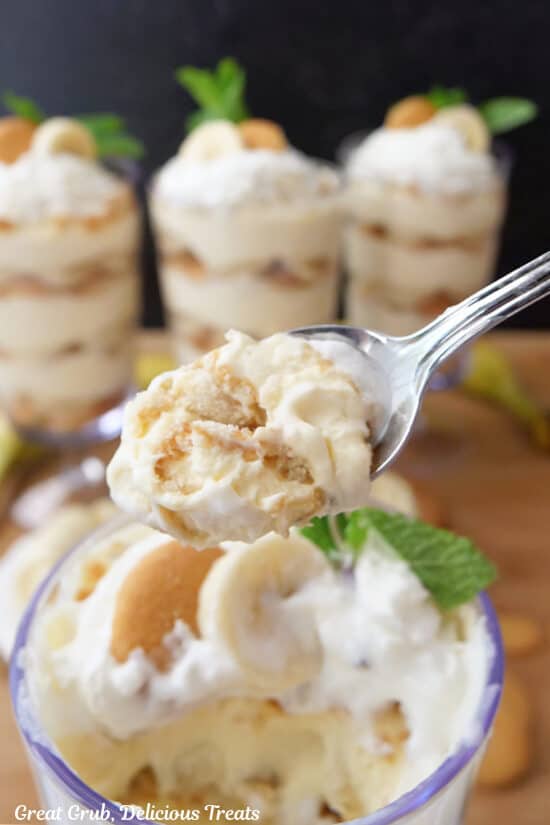 A spoonful of banana pudding held up over the parfait glass.