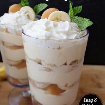 Two tall parfait glasses filled with banana pudding, vanilla wafers and sliced bananas.
