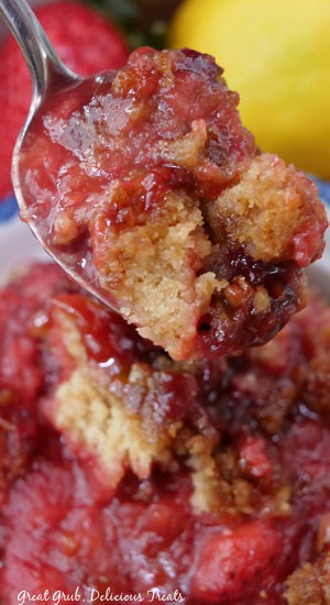A close up of a spoonful of strawberry cobbler.