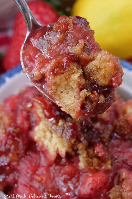 A close up photo of a spoon with a bite of cobbler on it.