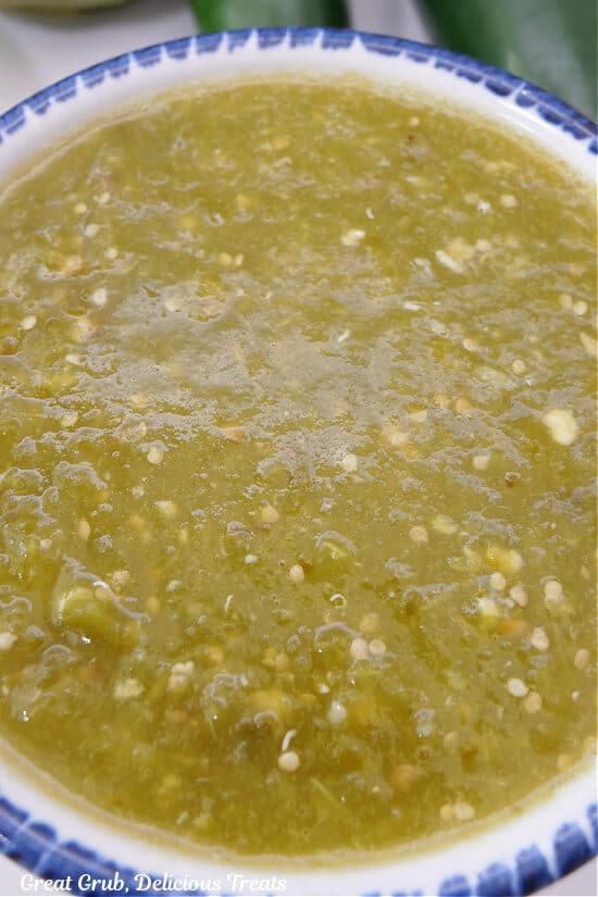 A super close up photo of a bowl of tomatillo salsa verde.