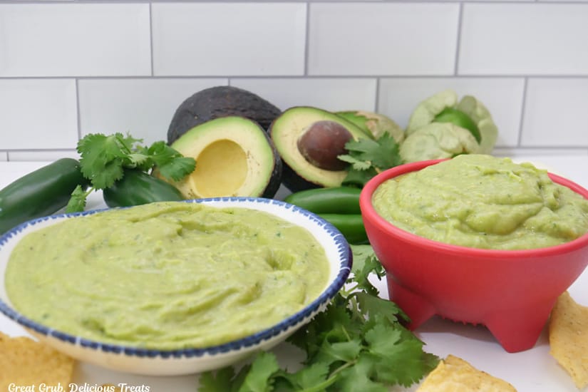 A horizontal photo of two bowls filled with creamy avocado salsa verde.