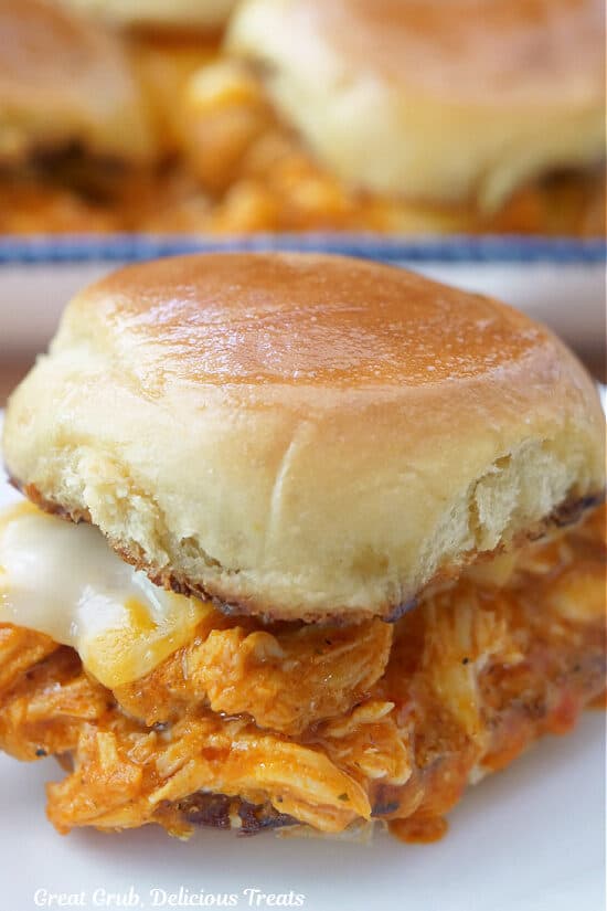 A small white plate with a single buffalo chicken slider on it.
