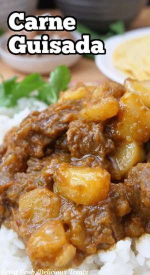 A bed of white rice with carne Guisada (meat and potato stew) on it.