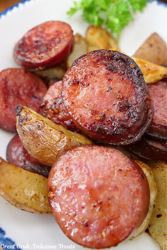 A super close up of air fryer sausage and potatoes on a white plate.