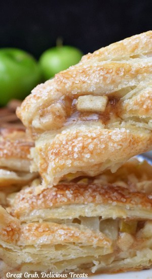 A close up of a slice of apple pastry held up to the camera lens.