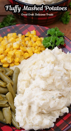 A red and black plaid plate with a serving of mashed potatoes, corn and green beans on it.