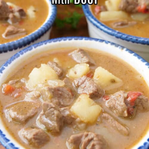 Three white bowls with blue trim filled with a serving of green chile stew.