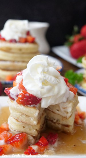 A stack of three mini pancakes with a bite taken out of them.