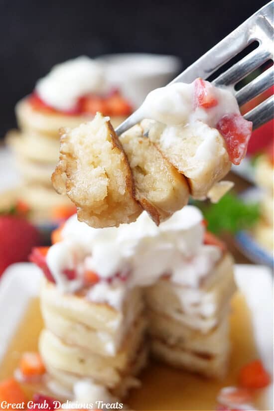 A close up photo of a bite of pancakes on a fork.