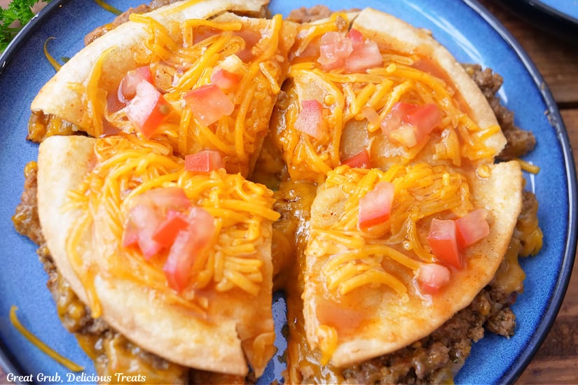 A whole copycat Taco Bell Mexican Pizza that is cut into four pieces on a blue plate.