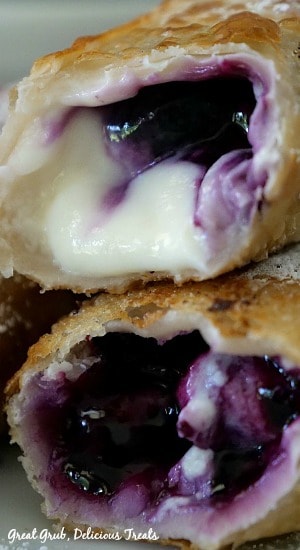 Two crispy egg rolls filled with cream cheese and blueberries.