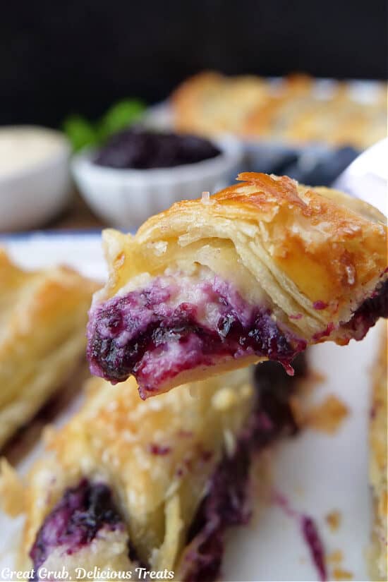 A close up of a bite of blueberry pastry on a fork.