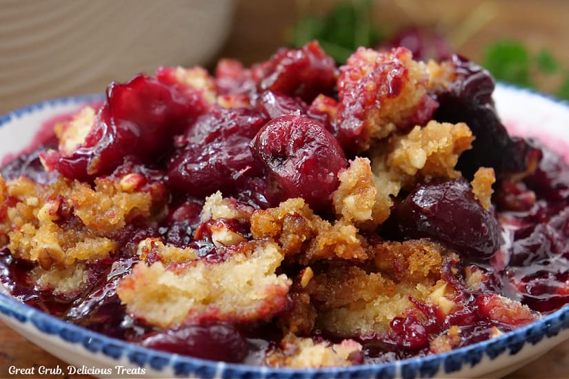 A horizontal photo of a bowl filled with cherry cobbler.