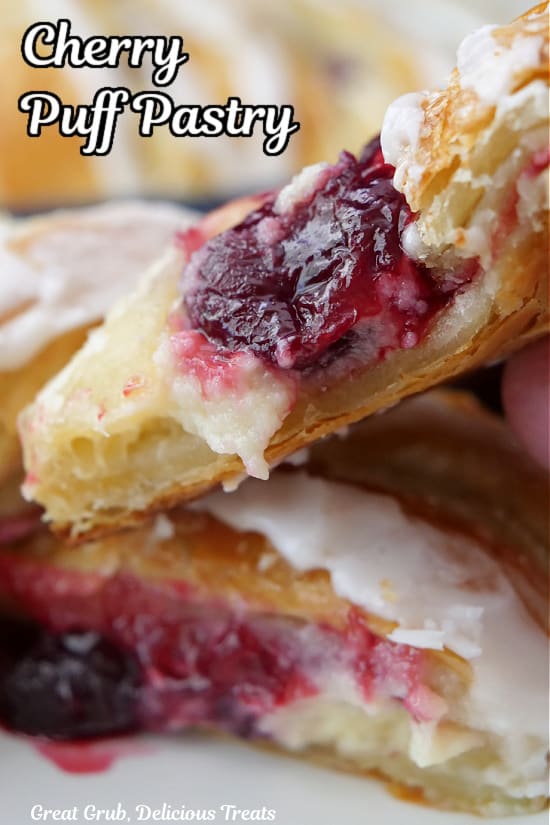 A close up of two slices of pastry filled with cream cheese and fresh cherries.