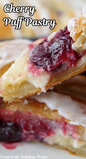 A close up of two slices of cherry pastry with cream cheese.