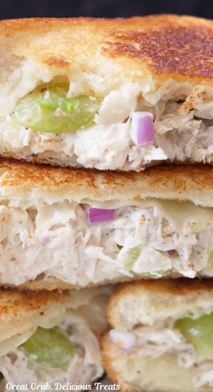 A close up of chicken salad grilled cheese sandwiches that have been cut in half and placed on top of each other.
