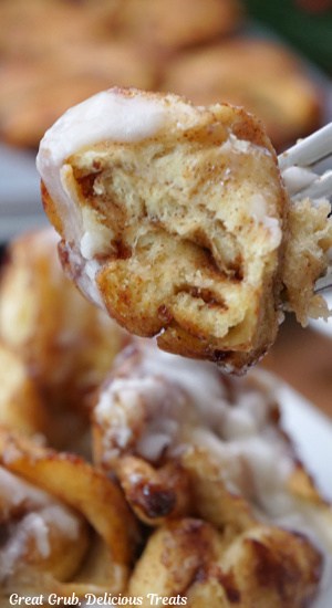 A close up photo of a bite of cinnamon roll pull apart bread on a fork.