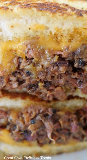 A close up photo of two halves of BBQ brisket grilled cheese sandwiches.