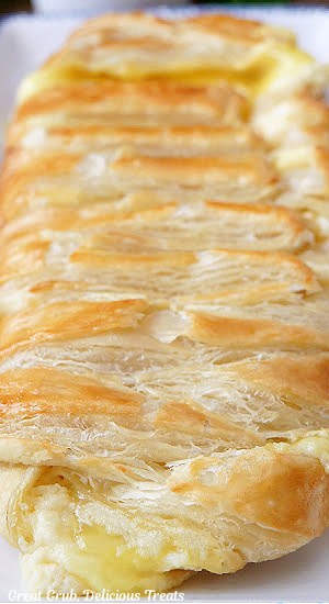 A close up of a whole baked puff pastry braid filled with cream cheese and lemon pie filling.