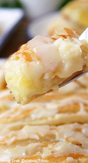 A close up of a bite of lemon cream cheese pastry on a fork.