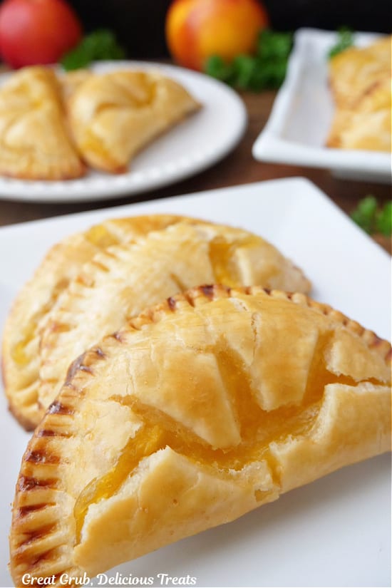 Two hand pies on a white plate with more in the background.