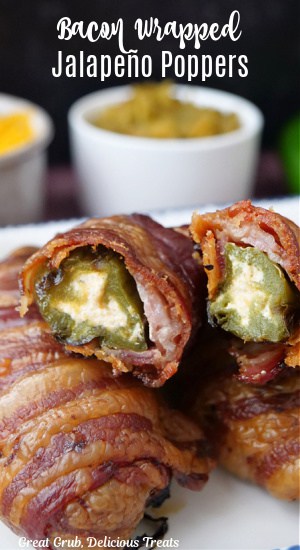 Three jalapeno peppers wrapped in bacon and one cut in half showing the inside ingredients..