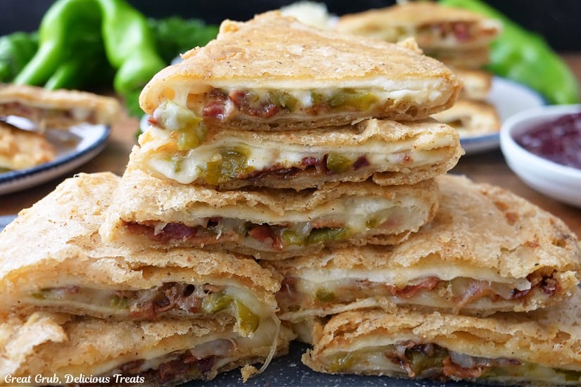 Seven pieces of deep fried cheese quesadillas with green chiles and bacon inside.