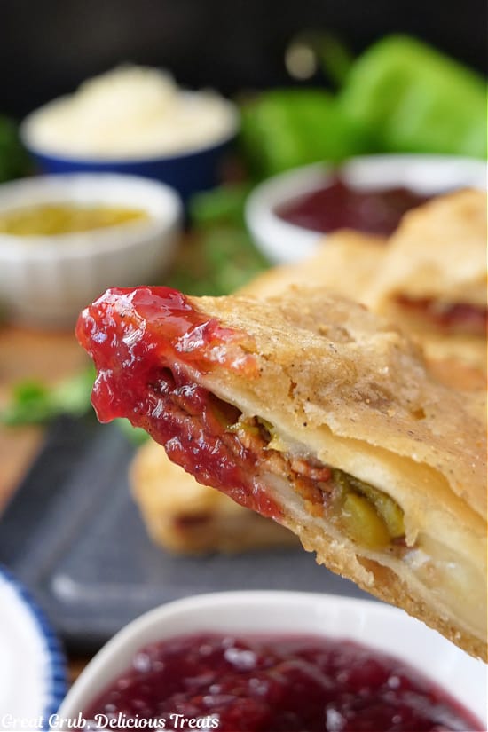 A piece of deep fried quesadilla after being dipped in raspberry jam.