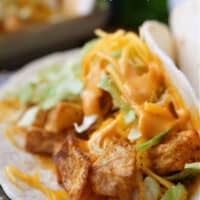 A flour tortilla with seasoned potatoes, cheese, lettuce and chipotle sauce.