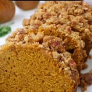 A white plate with four slices of pumpkin bread on it.