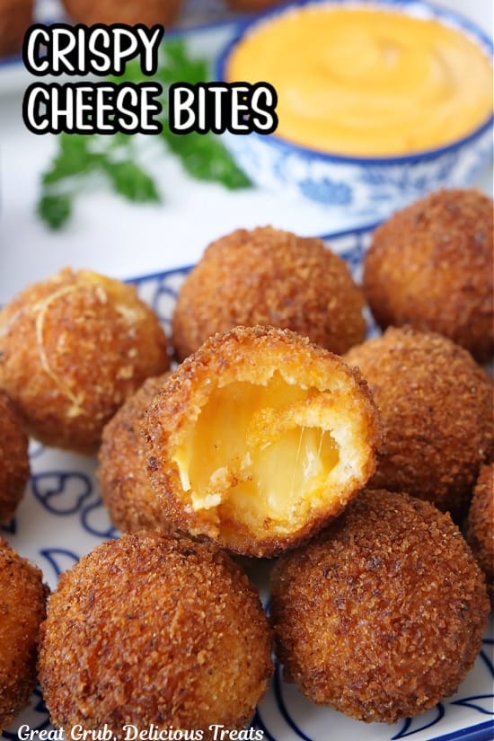 A white and blue plate with crispy cheese bites on it with a bite taken out of one of them.