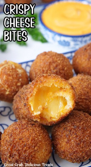 A few crispy cheese bites on a white and blue plate with a bite out of one.