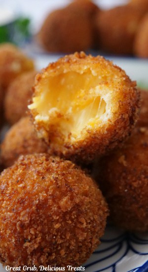 A close up of a few cheese bites with a bite taken out of one.