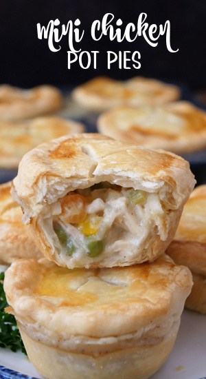 A few little pot pies with chicken and vegetables on a white plate with a bite out of one of them.