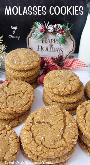 Molasses cookies on a white surface with holiday decorations in the background.