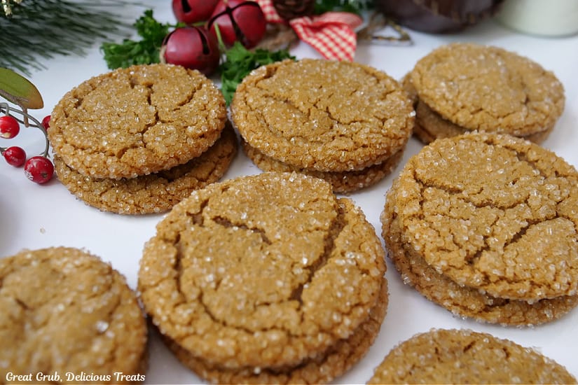 A horizontal photo of a dozen molasses cookies on a white surface.
