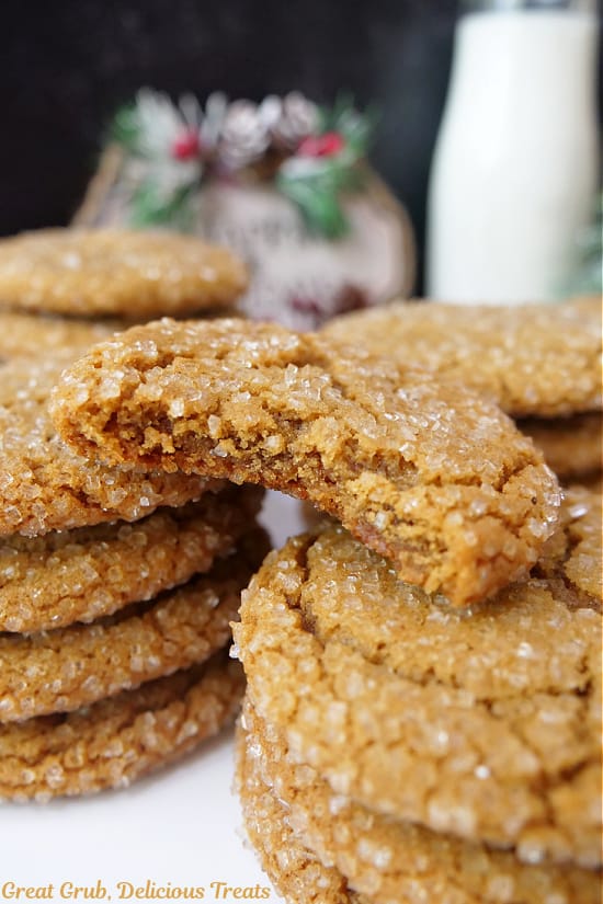 A few stacks of molasses cookies with a bite taken out of one of them and it is placed on top of two stacks.
