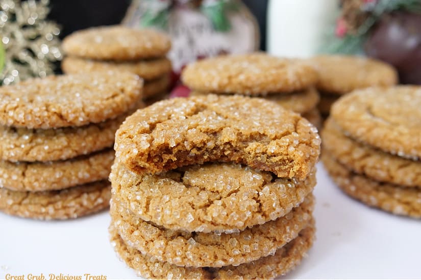 A horizontal photo of two dozen molasses cookies on a white surface.