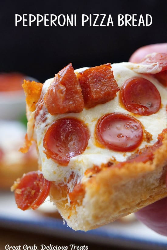 A close up of a slice of French bread pepperoni pizza on a hoagie roll.