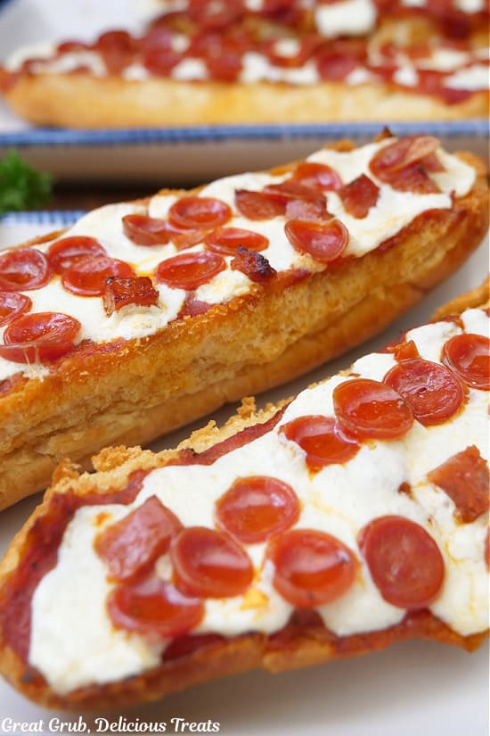 Pepperoni pizza bread on white plate with blue trim.