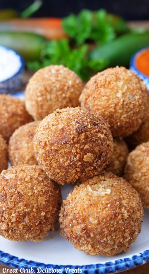 Crispy coated, deep-fried, cheese balls on a white plate with blue trim.