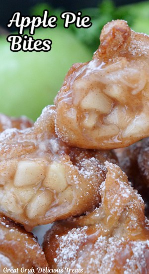 A close up of apple pie bites with a bite taken out of two of them showing the apple pie center.